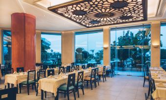 a large dining room with multiple tables and chairs arranged for a group of people to enjoy a meal together at Iberostar Selection Royal El Mansour