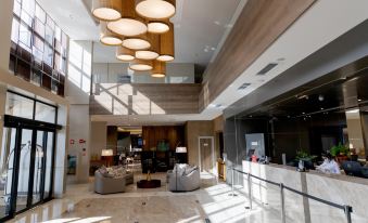 a modern hotel lobby with high ceilings , large windows , and pendant lights hanging from the ceiling at JL Hotel by Bourbon