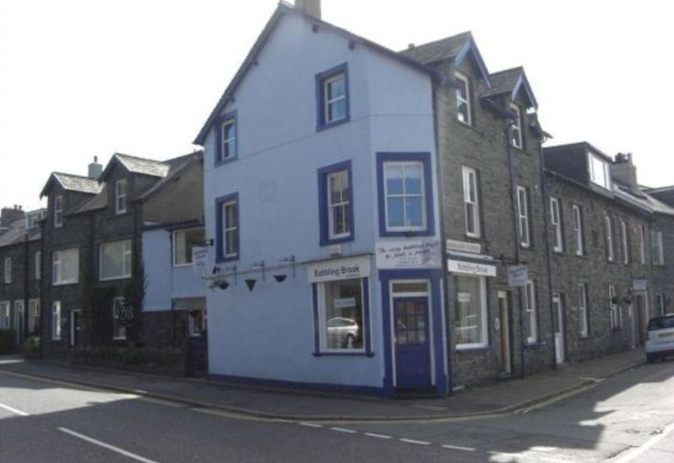 a small town with a blue and white building on the corner of a street at The Babbling Brook