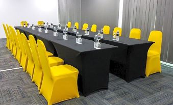 a conference room with yellow and black chairs arranged in rows , along with a long table and several chairs at Lakeview Terrace Resort Pengerang