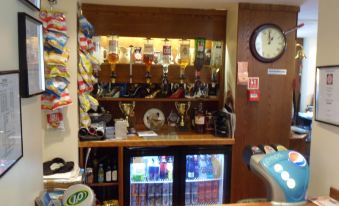 a well - stocked bar with various items , including beer taps and water bottles , as well as various sports memorabilia at The Shoes