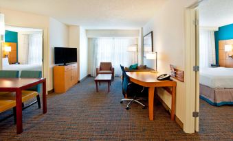 a modern hotel room with a desk , chair , and tv , as well as an office area with a chair at Residence Inn Bridgewater Branchburg