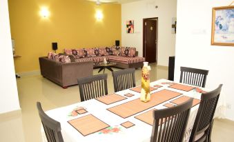a dining room with a table set for a meal and a living room with couches and chairs at Click to Go