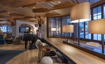 a cozy lounge area with wooden furniture , including a couch , chairs , and a dining table at Sunstar Hotel & Spa Grindelwald