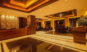 a luxurious hotel lobby with a large reception desk , marble flooring , and wooden ceiling panels at The Home Hotel