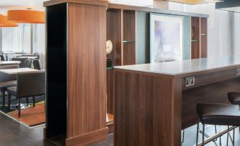 a wooden bar with a cabinet next to it , creating a unique and eye - catching design at Hampton by Hilton Birmingham Broad Street