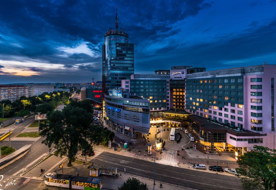 a bustling city scene at night , with tall buildings and traffic on the streets of a bustling city at Radisson Blu Hotel, Szczecin