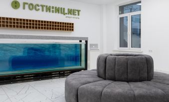a modern office with a large fish tank in the center , surrounded by comfortable seating at Gostinic