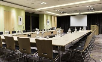 a conference room with a long table , chairs , and bottles of water set up for a meeting at Hotel Verde Cape Town Airport
