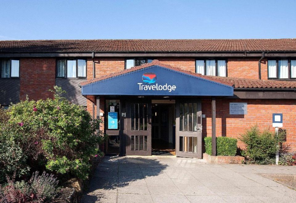 "a hotel entrance with a blue awning above the door and a sign that reads "" travelodge ""." at Travelodge Ludlow Woofferton