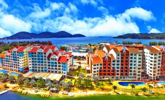 a large hotel complex with multiple buildings , including hotels and apartments , situated near a body of water at Marina Island Pangkor Resort & Hotel
