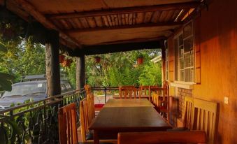 a wooden table and chairs are set up on a porch with a view of the trees at Victoria Guest House