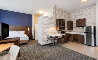 a modern hotel room with a bed , kitchenette , and dining area , all under a white ceiling at Residence Inn Riverside Moreno Valley