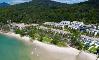 aerial view of a beach resort surrounded by trees and mountains , with a body of water in the background at Banyan Tree Krabi