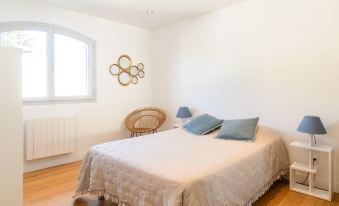 a white bedroom with a large bed , two chairs , and a window , giving it a cozy and inviting atmosphere at Dade