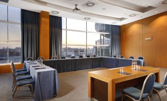 a large conference room with a long wooden table , chairs , and a view of the city at Hotel Diamante