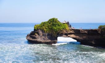 a large rock formation with a small building built into it , overlooking the ocean at favehotel Langko Mataram - Lombok
