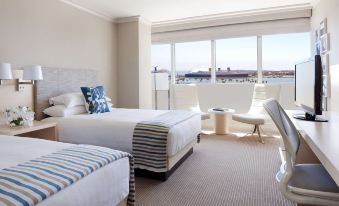 a hotel room with two beds , one on each side of the room , and a view of the ocean at Hyatt Regency Long Beach