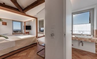 a modern bedroom with a large window , wooden beams on the ceiling , and a bathroom nearby at Bosco Della Spina
