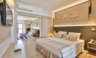 a large bed with white linens is in a room with wooden floors and a sliding door at San Marino Suites Hotel by Nobile