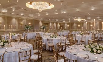 a large banquet hall with numerous round tables covered in white tablecloths and chairs arranged for a formal event at Druids Glen Resort