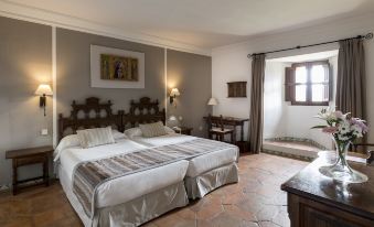 a hotel room with two beds , one on the left and one on the right side of the room at Parador de Siguenza
