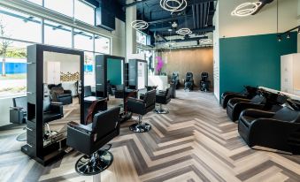 a modern salon with black chairs and a long table , creating a stylish atmosphere for the stylist at Aloft Seattle Redmond