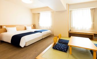 a hotel room with two beds , a dining table , and a chair , all neatly arranged at Hotel WBF Grande Asahikawa（Natural Hot Spring MinaPirika No Yu)