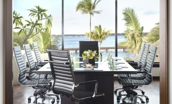 a conference room with a large table , chairs , and a view of the ocean through a window at Four Seasons Resort Mauritius at Anahita
