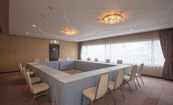 a large conference room with several chairs arranged in a semicircle around a long table at Century Plaza Hotel