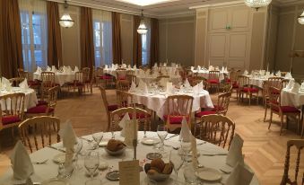 a large , elegant dining room with numerous tables and chairs arranged for a formal event at Grand Hotel la Cloche Dijon - MGallery