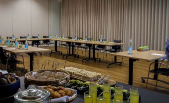 a long table with various food items and drinks is set up in a conference room at Octant Ponta Delgada
