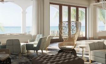 a modern living room with large windows offering an ocean view , featuring comfortable seating arrangements and a dining table at Isla Bella Beach Resort & Spa - Florida Keys