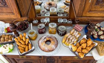 a dining table filled with an assortment of food , including donuts , croissants , and other baked goods at Syros Atlantis