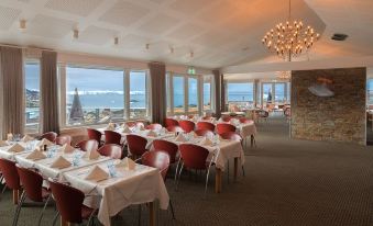 a dining room with tables and chairs arranged for a large group of people to enjoy a meal at Hotel Arctic