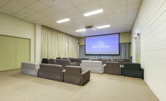 a large room with multiple chairs arranged in rows , and a projector screen mounted on the wall at North Pier Hotel