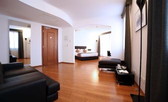 a modern hotel room with wooden floors , black leather furniture , and a black bedspread on the bed at Hotel San Rocco
