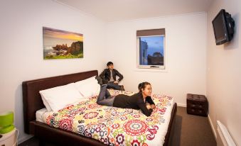 a man and a woman are sitting on the edge of a bed in a bedroom at The Island Accommodation