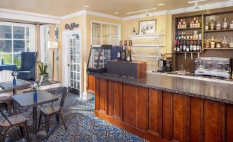 a well - stocked coffee shop with a bar , chairs , and tables , as well as a dining area at Historic Boone Tavern