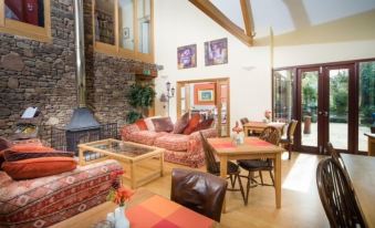 a spacious living room with a large window , multiple couches , chairs , and a dining table at Willowbeck Lodge Boutique Hotel