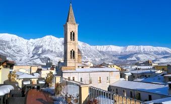 a snow - covered town with a church at the center , surrounded by snow - covered mountains in the background at Legacy