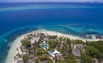 an aerial view of a tropical resort with sandy beaches , clear blue water , and lush greenery at Castaway Island Fiji
