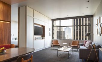 a modern living room with a large window , wooden furniture , and a flat screen tv at Grand Hyatt Denver