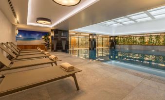 a modern indoor pool area with rows of wooden loungers and large windows , creating an inviting atmosphere at Golden Tulip Istanbul Bayrampasa