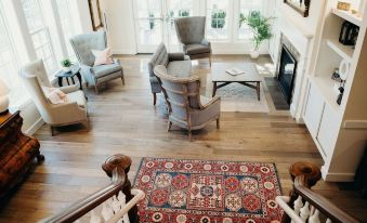 a spacious living room with hardwood floors , a fireplace , and a rug on the floor at Briar Barn Inn