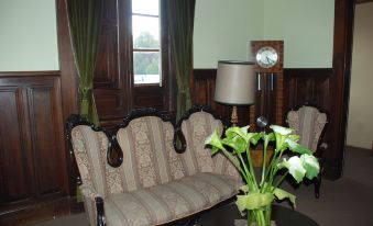 a living room with a wooden table , a couch , and a clock on the wall at Las Mercedes