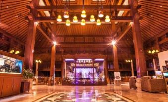a large , luxurious hotel lobby with a wooden ceiling and floor , featuring chandeliers hanging from the ceiling at Lorin Dwangsa Solo Hotel