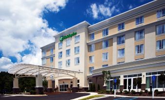 "a large hotel with a green sign that says "" holiday inn "" and a parking lot" at Holiday Inn Birmingham - Hoover