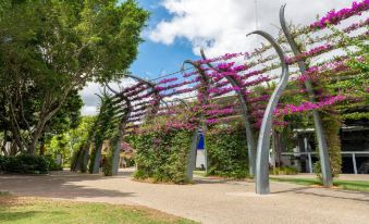 a park with a metal sculpture of trees and flowers , creating a unique and artistic display at Gambaro Hotel Brisbane
