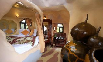a luxurious bedroom with a four - poster bed , a large vase , and a painting on the wall at Crazy House